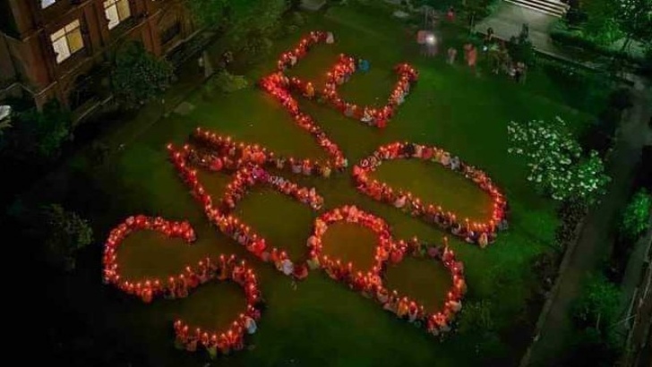 ঢাবির সুফিয়া কামাল হলের শিক্ষার্থীরা মোমবাতি জ্বালিয়ে লিখেছেন ‘সেইভ বিডি’।